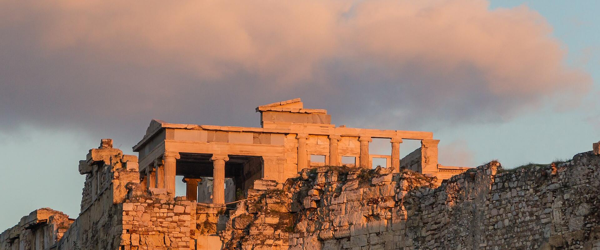 The Erechtheion on the Acropolis of Athens glowing at golden hour beneath a full moon