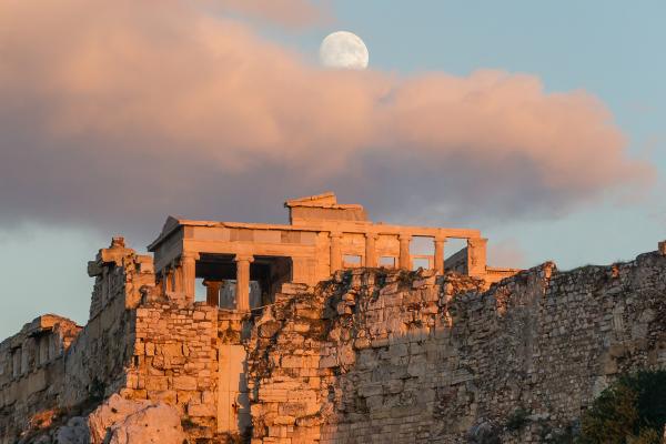 The Erechtheion on the Acropolis of Athens glowing at golden hour beneath a full moon