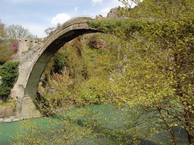 The single high stone arch of the Konitsa bridge over the green Aoos river