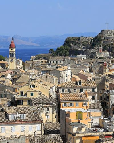 The rooftops of Corfu Old Town with the Old Fortress on its headland and the sea beyond.