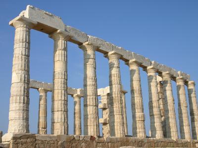 The image shows the ancient Greek temple of Poseidon at Cape Sounion, featuring its iconic Doric columns against a clear blue sky.