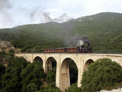 The Moutzouris steam train crossing a stone viaduct on the Pelion railway