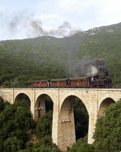 The Moutzouris steam train crossing a stone viaduct on the Pelion railway