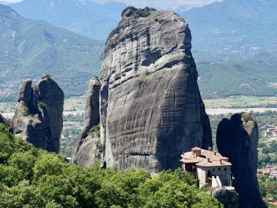 A towering Meteora rock pillar above the Roussanou Monastery, with the Pindus mountains behind
